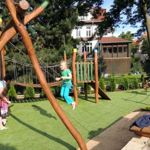 Children in the new playground made of acacia wood and artificial grass