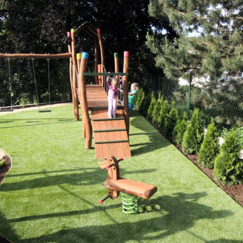 Children's playground with artificial grass in the garden
